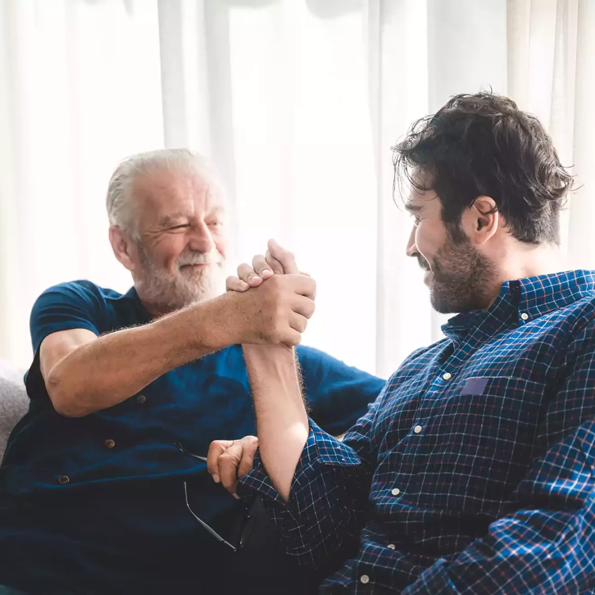 Older man and younger man locking hands