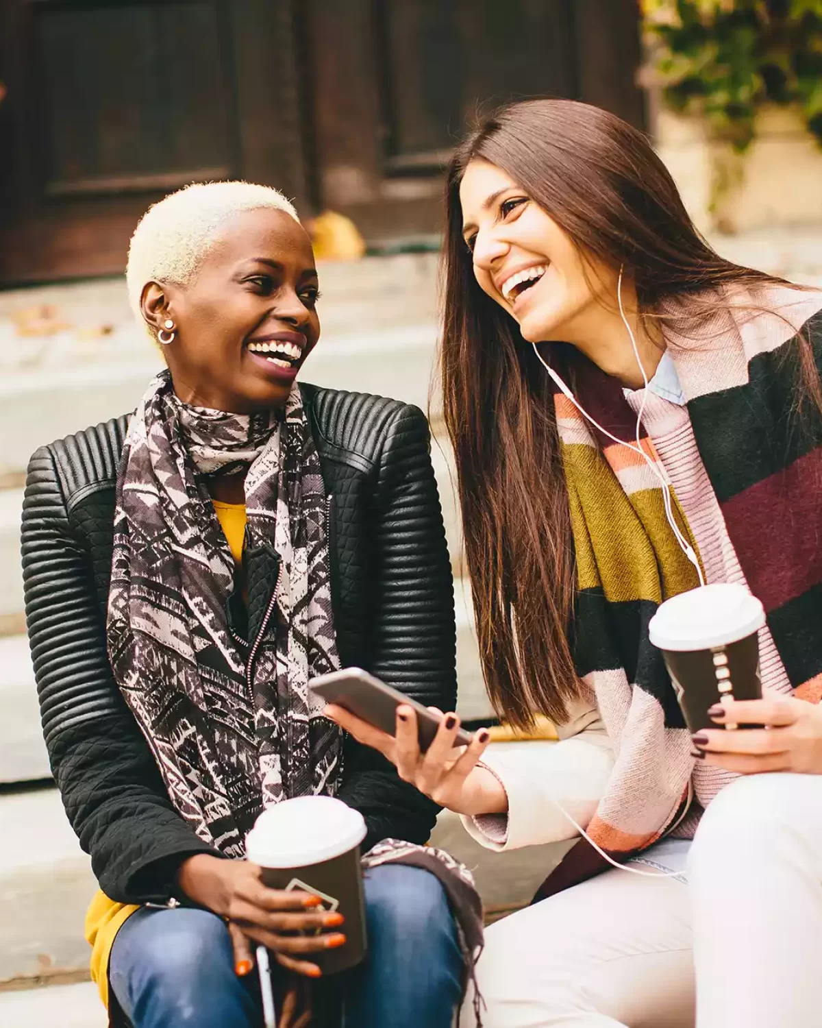 Two female friends talk and listen to music